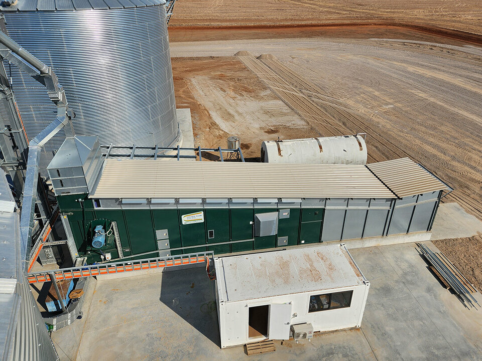 Top down view of an Alvan Blanch grain dryer next to a large feed silo