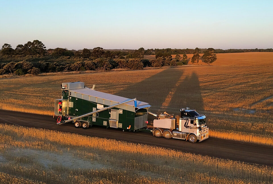 A truck tows an Alvan Blanch dryer down a remote Australian country road